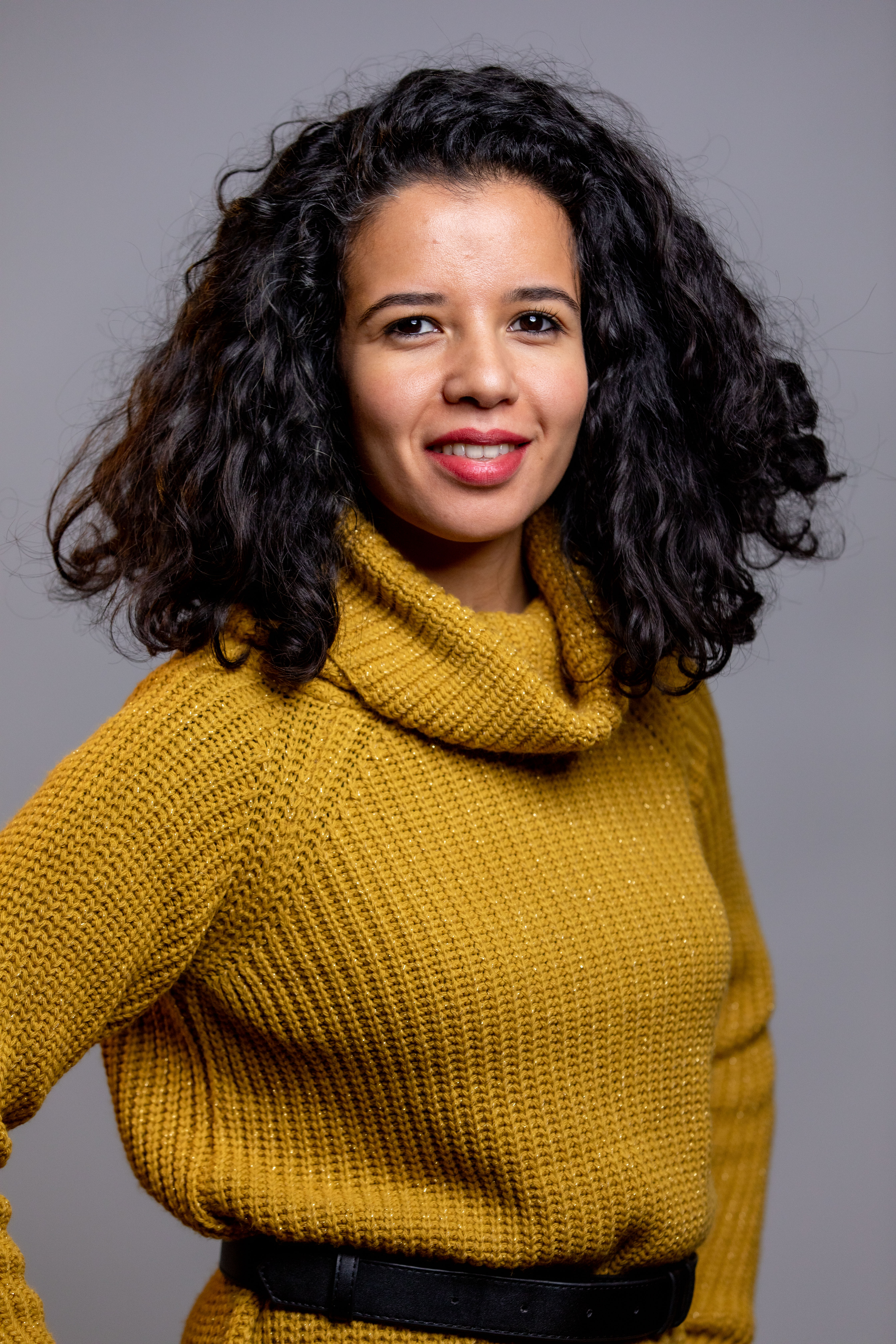 Portrait d&pos;une femme souriante avec un fond neutre, utilisé comme arrière-plan pour le texte superposé.