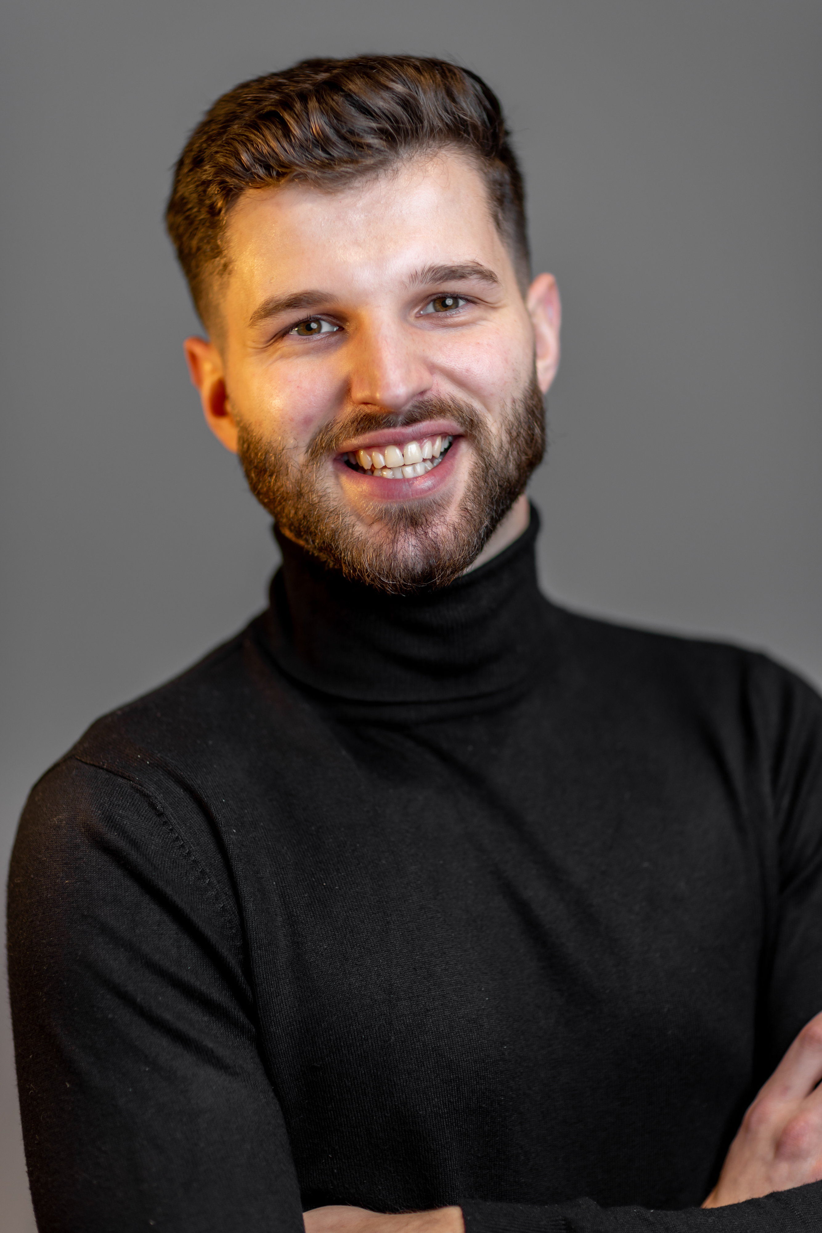 Portrait d&pos;un homme souriant avec un fond neutre, utilisé comme arrière-plan pour le texte superposé.