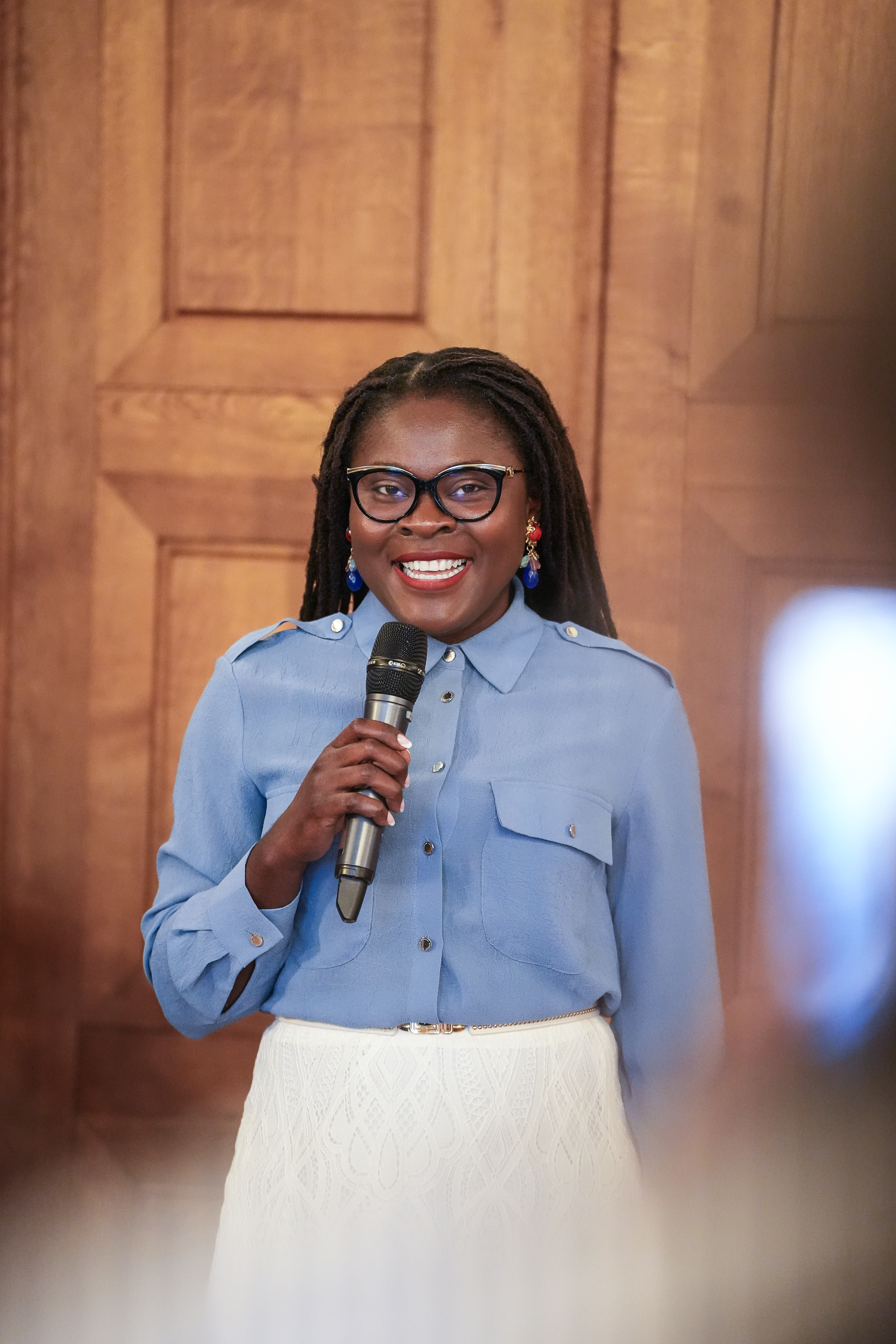 Femme en pull rouge présentant devant un ordinateur portable lors d'une réunion professionnelle